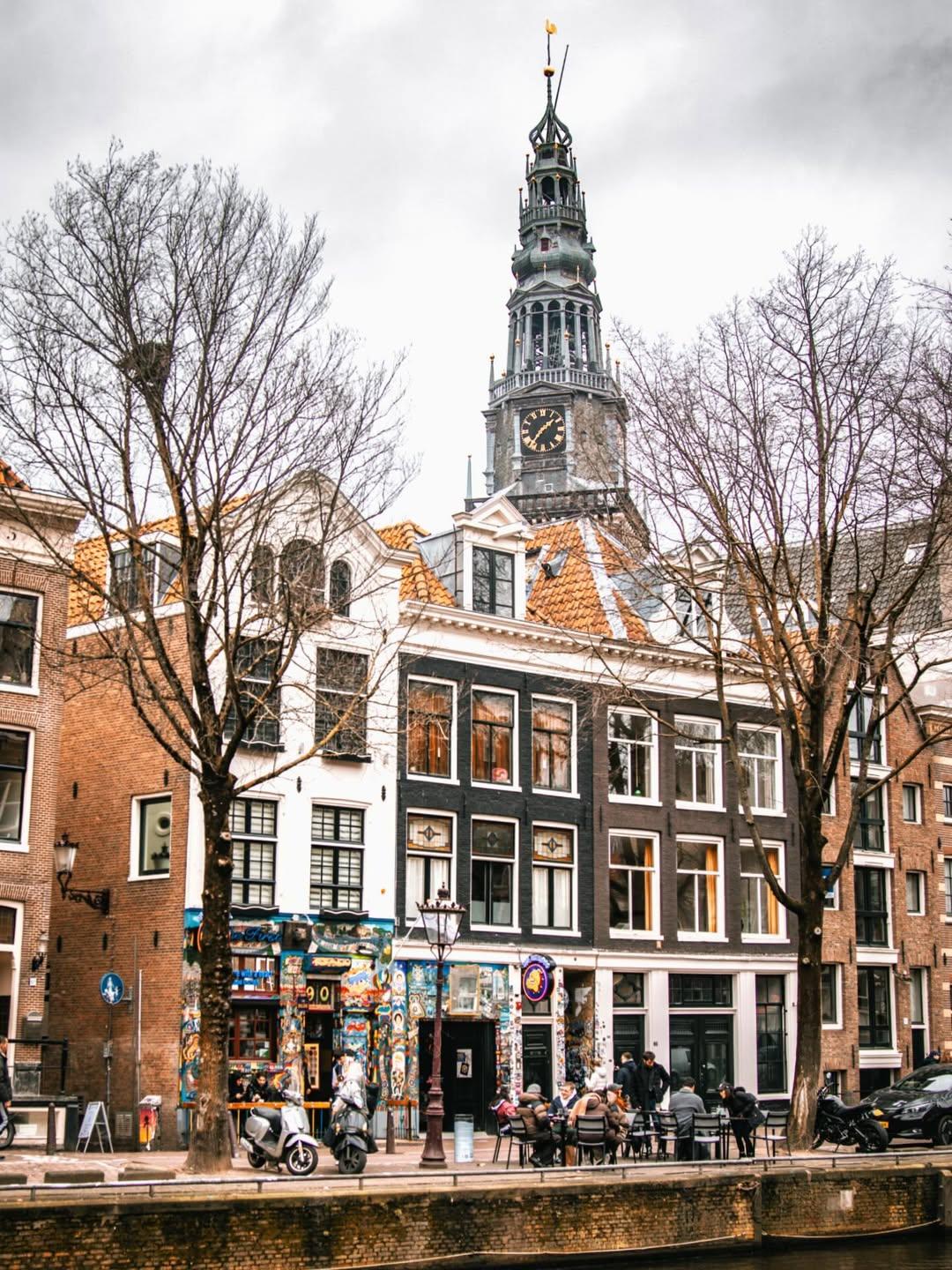 The Bulldog The First beside an Amsterdam canal with the Zuiderkerk tower above