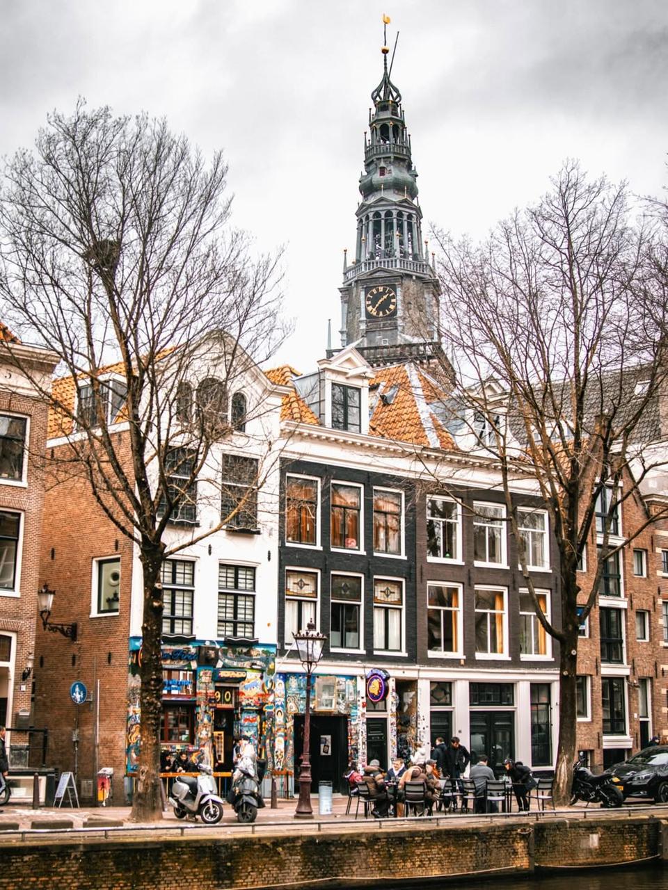 The Bulldog The First beside an Amsterdam canal with the Zuiderkerk tower above