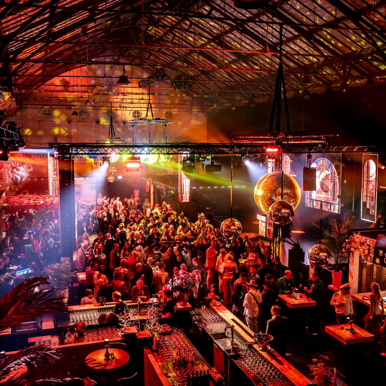 A crowded Bulldog event space lit in red and gold