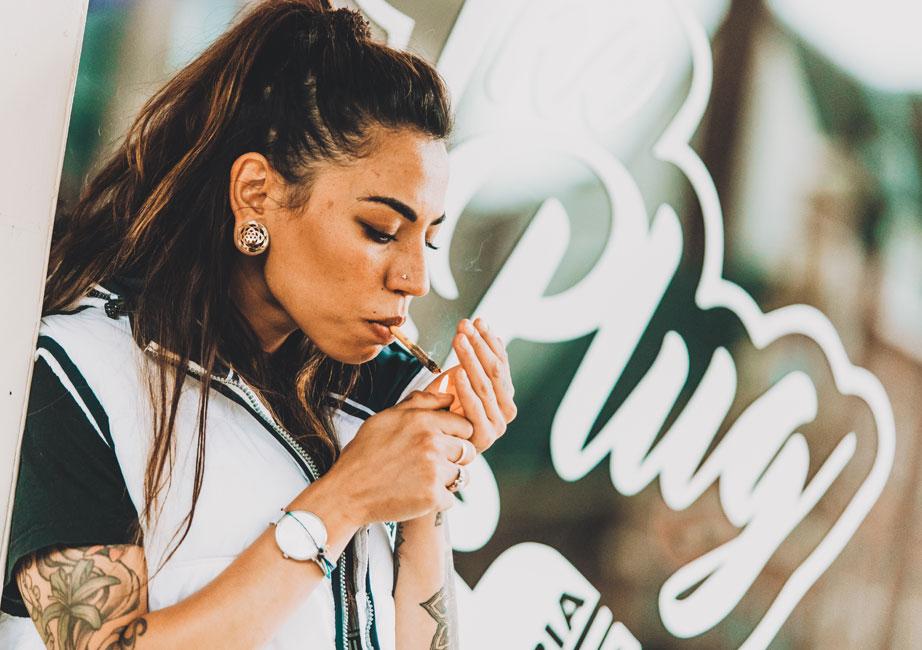 Customer smoking in front of The Plug branding