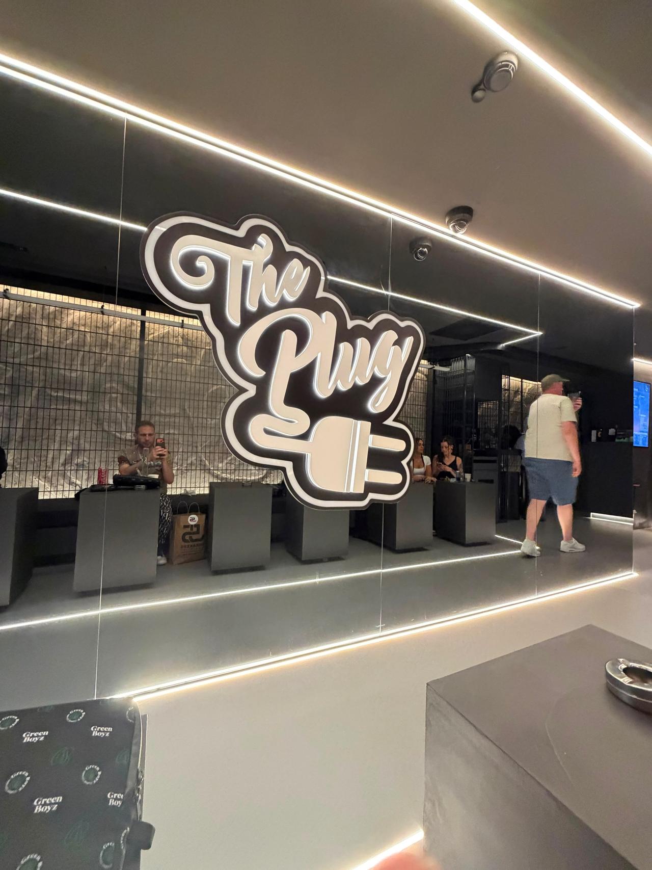 The Plug illuminated logo inside a venue